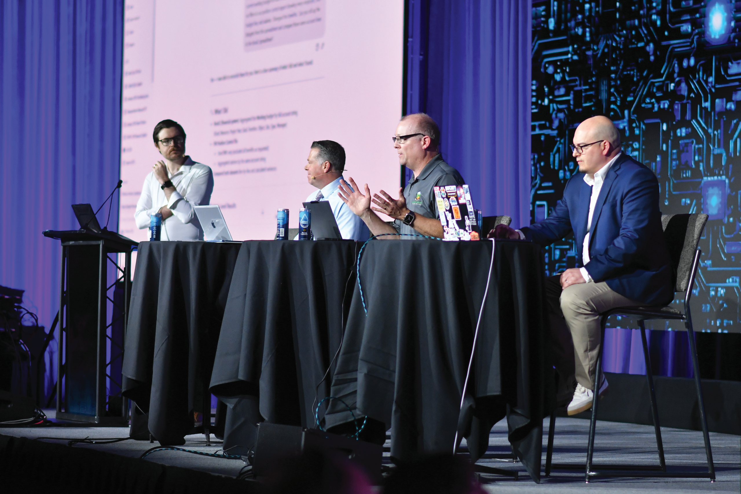 men having a discussion on conference stage